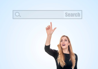 An attractive young woman points the finger at the blank line of a virtual search Internet browser.