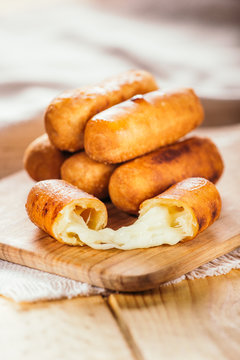 Cheese fingers, typical Venezuelan appetizer called tequeños  on a wooden board