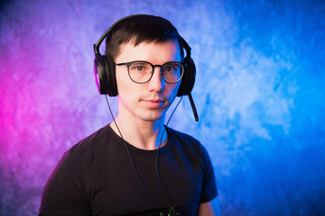 Portrait of a joyful young gamer in headphones. Computer Games Concept