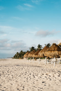 View of palapa on beach against cloudy sky