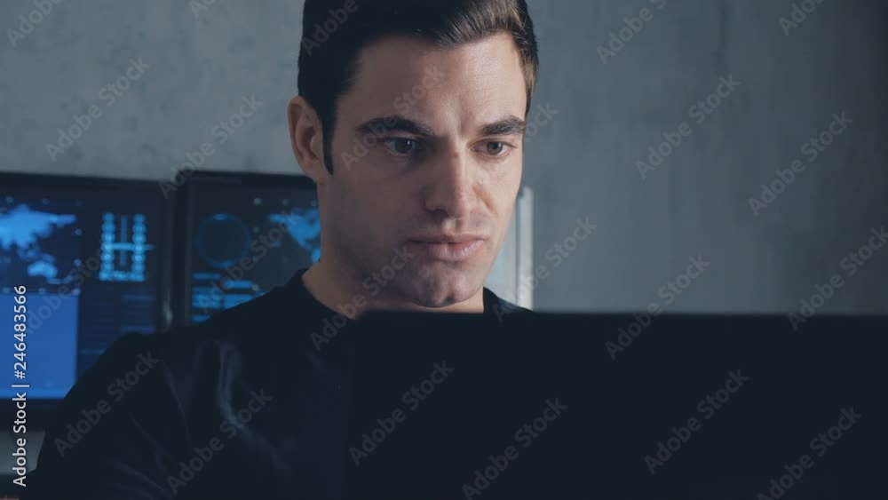 Wall mural developer programmer working on computer in a data center filled with monitor screens. steadicam sho