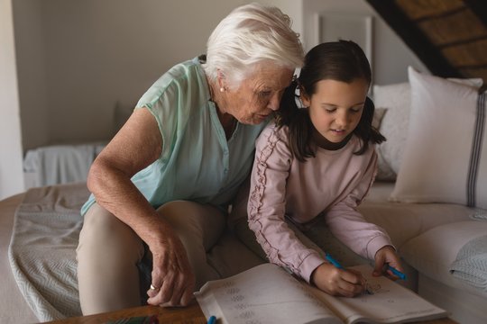 Grandmother helping her granddaughter with homework 