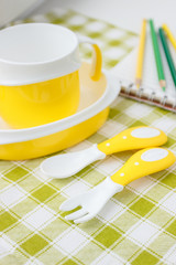 Set of yellow empty dishes for baby. Tableware for the first feeding, soft focus background