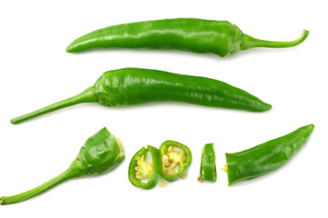 green hot chili peppers with slices isolated on white background top view