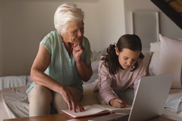 Grandmother helping her granddaughter with homework