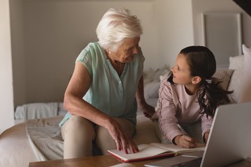 Fototapeta na wymiar Grandmother helping her granddaughter with homework