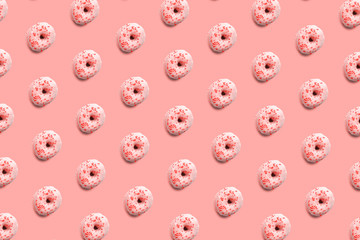 Sweet and tasty donuts with colorful icing and powder, like a pattern on a bright pastel color background. Homemade dessert and baking concept.