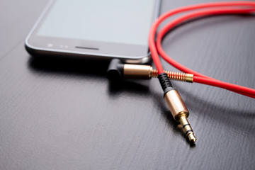 Naklejka premium Jack cable for connecting headphones. Telephone and accessories on the table.