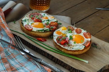 Two toasted bread with sunny side fried egg and tomato
