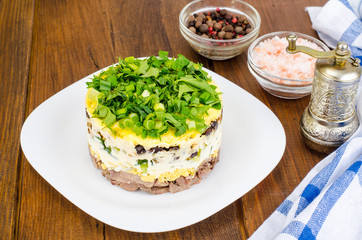 Layered portion salad with meat, cucumber, egg and mayonnaise