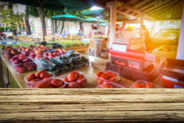 Wooden table on the street market among fresh vegetables and fruits   