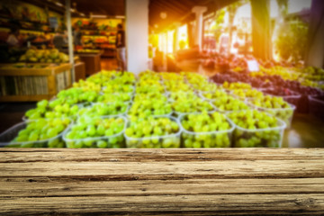 Wooden table on the street market among fresh vegetables and fruits   