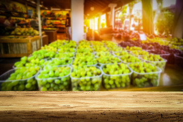 Wooden table on the street market among fresh vegetables and fruits   
