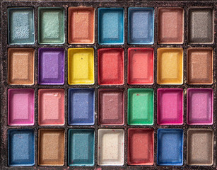 Cosmetic powder on a black glossy background top view