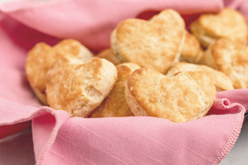 Homemade Heart-Shaped Biscuits in a Bread Basket Lined with a Pink Napkin