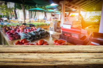 Wooden table on the street market among fresh vegetables and fruits   
