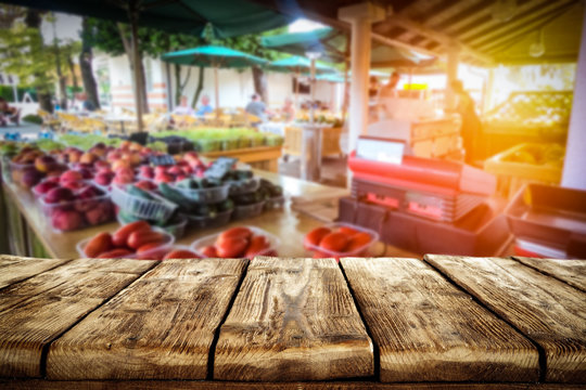 Wooden table on the street market among fresh vegetables and fruits   