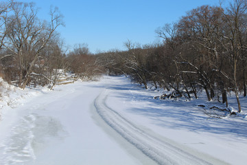 Fototapeta na wymiar Snow covers the Des Plaines River at Campground Road Woods