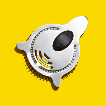 Cocktail strainer on a yellow background