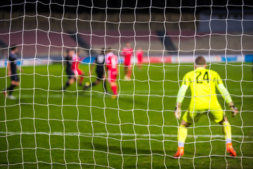 Football, soccer photo - football net and soccer game in background