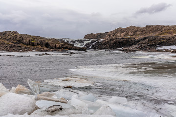 Eisblock vor einem Wasserfall im Winter in Island