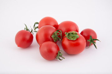 Seven fresh cherry tomatoes lie side by side isolated on white background. Close-up photo