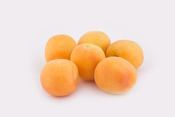 Six apricots lie side by side isolated on white background. Close-up photo