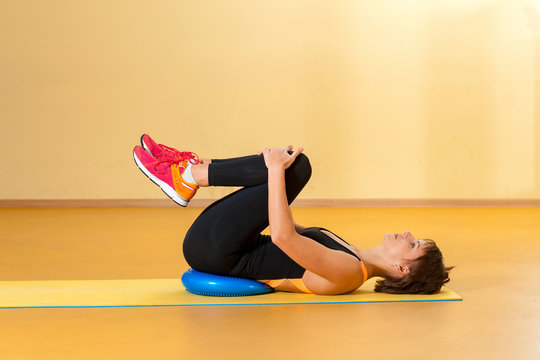 Sports woman doing therapeutic exercises in indoor gym