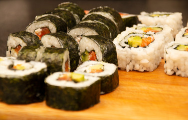 homemade sushi rolls laid out on a wooden board