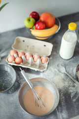 Up down shot of pancakes in the kitchen, home with flowers, eggs, fruits on the table.