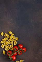 Fototapeta na wymiar Pasta and tomatoes on a concrete background. Italian food background. Ingredient for cooking.