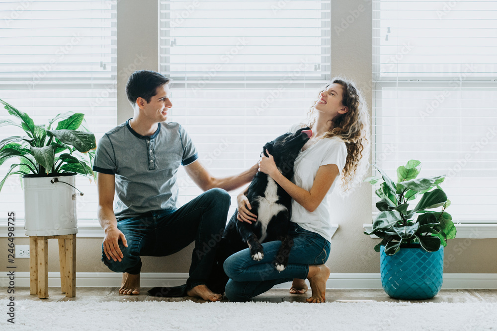 Wall mural Happy Couple with dog at home