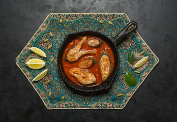 Top view of spicy and hot Bengali fish curry. Indian food. Fish curry with red chili, curry leaf, coconut milk. Asian cuisine.
