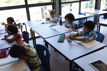 Schoolkids studying at desk in classroom