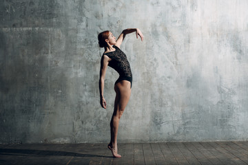 Ballerina female. Young beautiful woman ballet dancer, dressed in professional outfit, pointe shoes and black body.