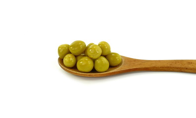 Canned green peas in a wooden spoon isolated on white background