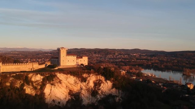 An aerial reveal shot of Rocca di Angera castle over watching a town in the northern Italy.