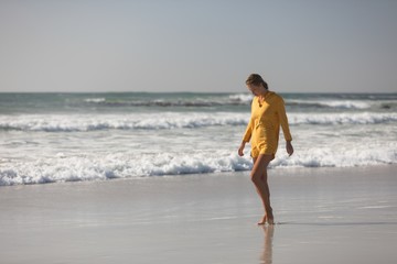 Woman walking on the beach near seashore