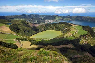 View into the volcanic crater Caldera Sete Cidades, in front of the crater lake Lagoa de Santiago, in the back right crater lakes Lagoa Azul, in the back left the village Sete Cidades, island Sao Miguel, Azores, Portugal, Europe