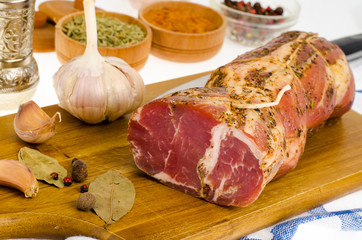 Smoked pork neck on wooden cutting board, spices