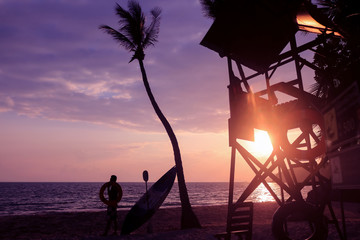 Lifeguard ready to take care of tourists on the beaches. Asian Lifeguard standing near the tower at sunrise