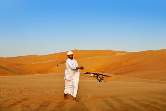 Falconer in the desert luxury hotel Anantara Qasr Al Sarab, in the middle of high sand dunes, in the Empty Quarter called sand desert Rub Al Khali, Emirate of Abu Dhabi, United Arab Emirates, Asia