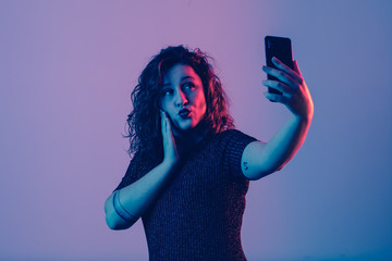 young girl making selfie and sending kiss