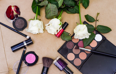 Obraz na płótnie Canvas lipstick, mascara, shadows, beautiful roses, on a leather sofa. all for makeup