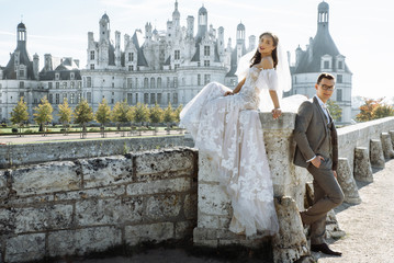Old Castle. Beautiful and stylish bride and groom posing against the backdrop of the castle in...