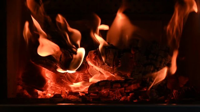 warm flickering flames of wood fire in stove fireplace  in slow motion
