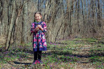 Portrait of a beautiful little girl with corydalis flowers.