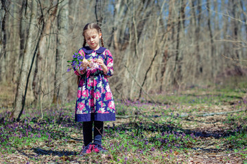 Portrait of a beautiful little girl with corydalis flowers.