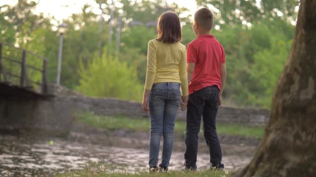 Cute children holding hands at golden sundown