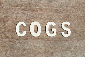 Alphabet letter in word COGS (Abbreviation of Cost of goods sold)  on wood background